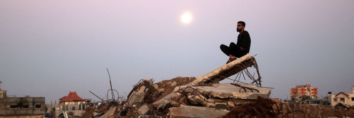 Palestinian man sits atop rubble in Gaza