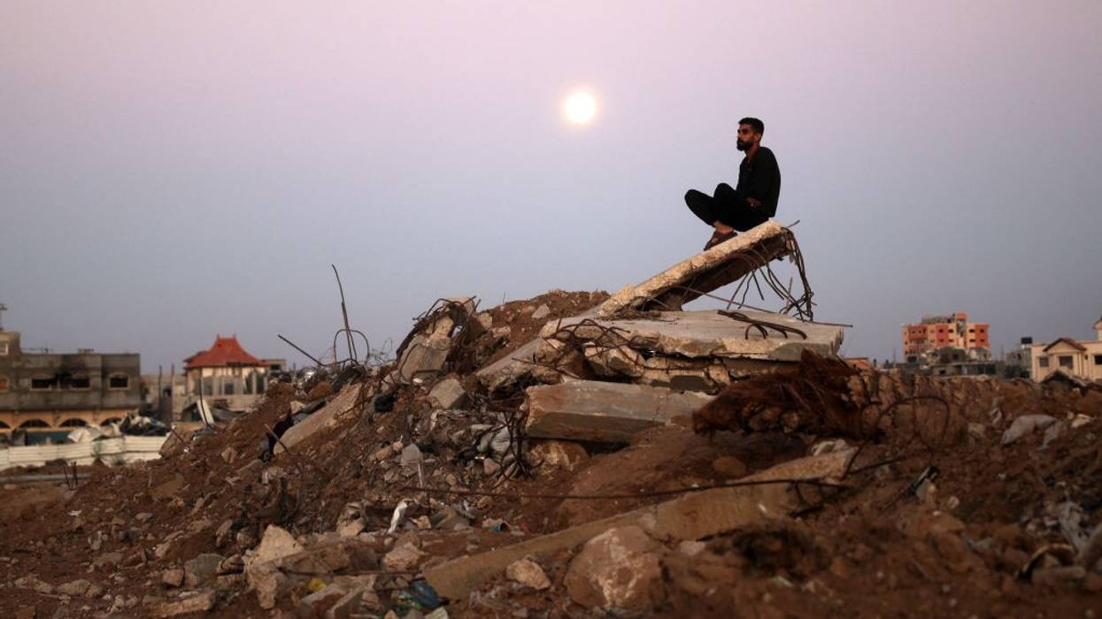 Palestinian man sits atop rubble in Gaza