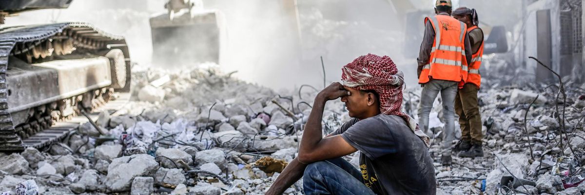 Palestinian man sits in rubble in Gaza
