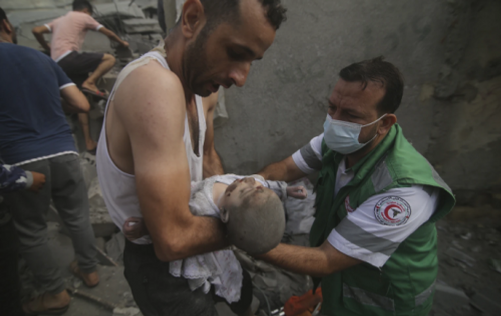 Palestinian medic takes a dead baby pulled out of destroyed buildings in Rafah.  