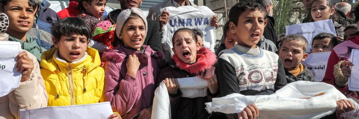 Palestinian men and children gather for a demonstration in Rafah