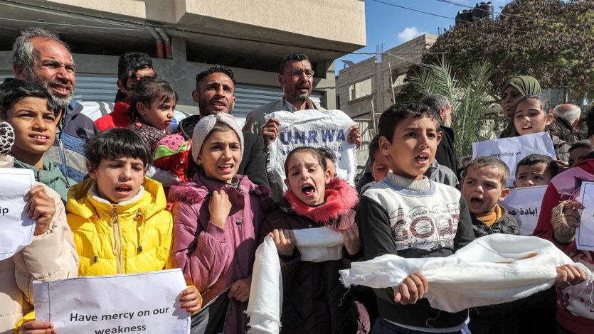 Palestinian men and children gather for a demonstration in Rafah