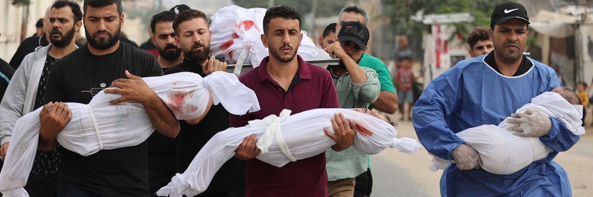 Palestinian men carry civilians—including children wrapped in white cloths—killed by Israeli attacks on Gaza.