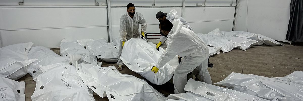 Palestinian mortuary workers unload the bodies of Palestinian prisoners returned by Israel