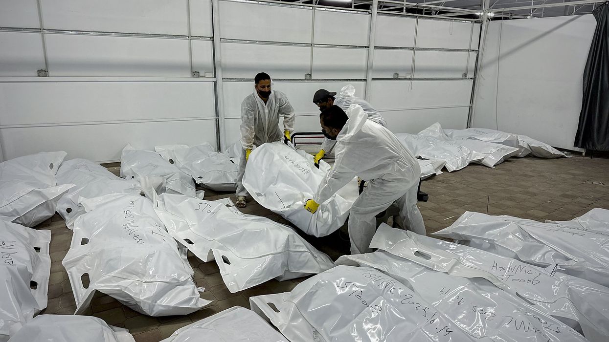 Palestinian mortuary workers unload the bodies of Palestinian prisoners returned by Israel