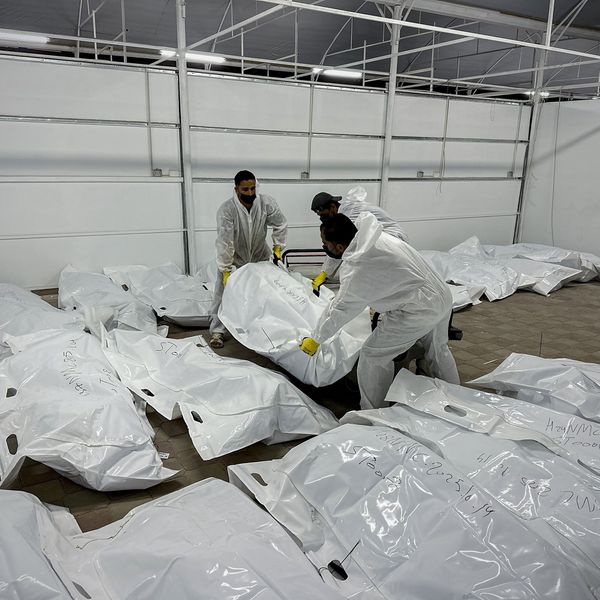 Palestinian mortuary workers unload the bodies of Palestinian prisoners returned by Israel