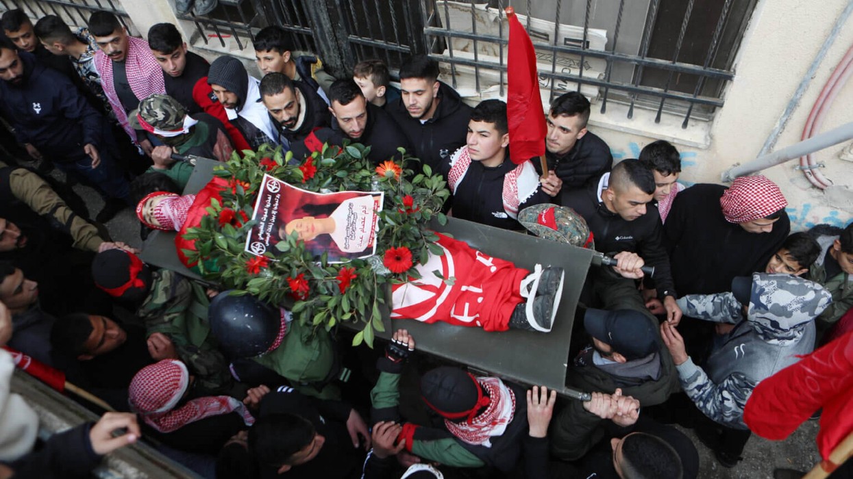 Palestinian mourners carry the body of 15-year-old Adam Ayyad during his funeral at Bethlehem’s Dheisheh refugee camp on January 3.
