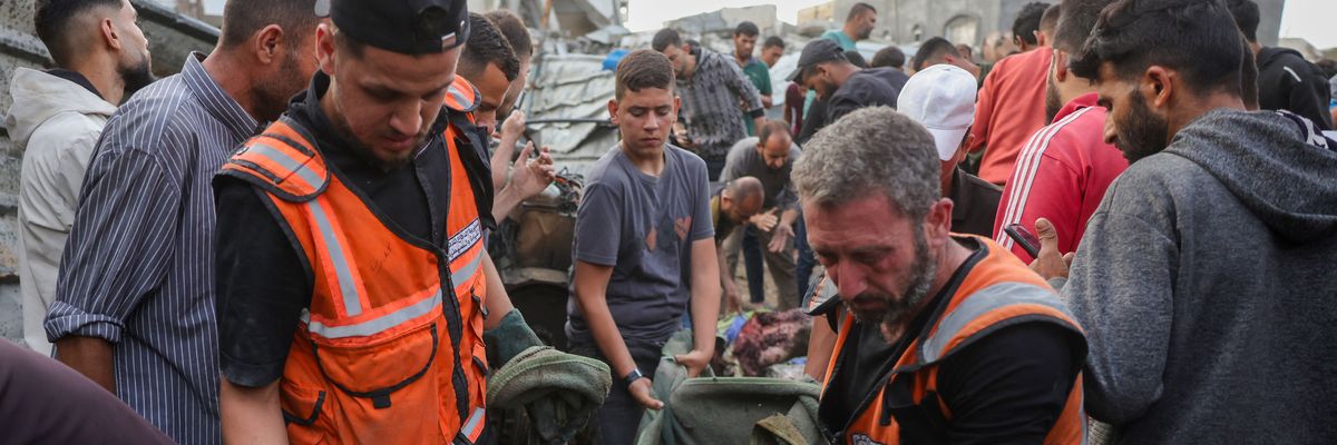 Palestinian rescuers remove the body of a victim