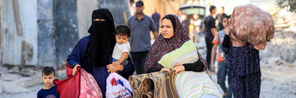 Palestinian women and children flee with their belongings from Gaza