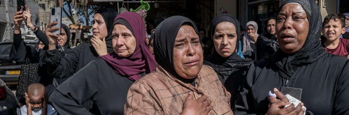 Palestinian women cry during the funeral of four young men...