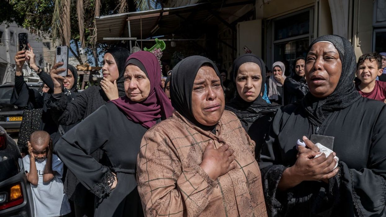 Palestinian women cry during the funeral of four young men...