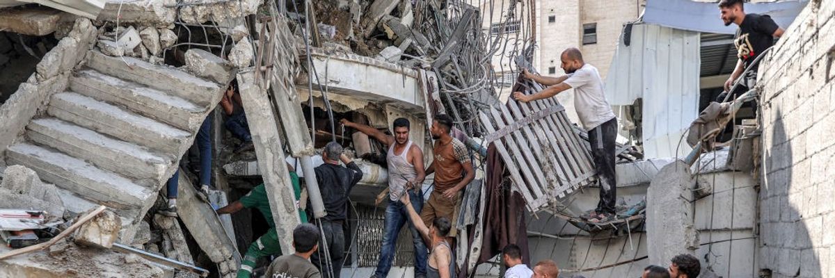 Palestinians attempt to rescue people trapped in the rubble of a building bombed by Israeli forces.
