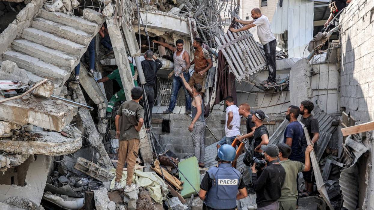 Palestinians attempt to rescue people trapped in the rubble of a building bombed by Israeli forces.