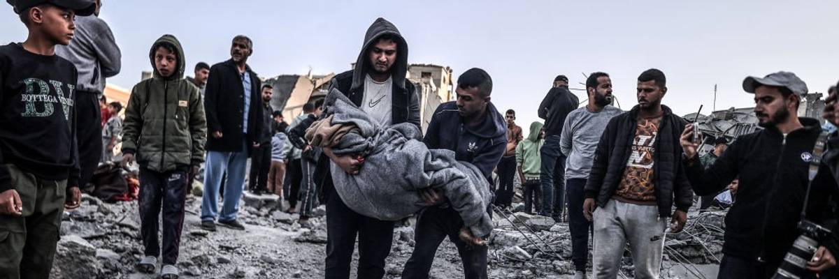 Palestinians carry a body pulled from the rubble