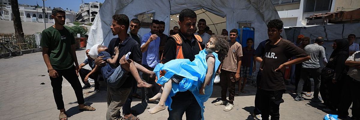 Palestinians carry a wounded children to al-Ahli Baptist Hospital