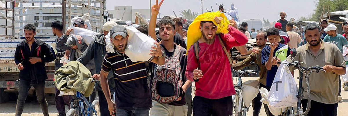 Palestinians carry aid