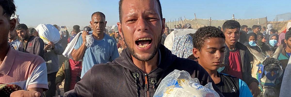 Palestinians carry bags of humanitarian relief supplies