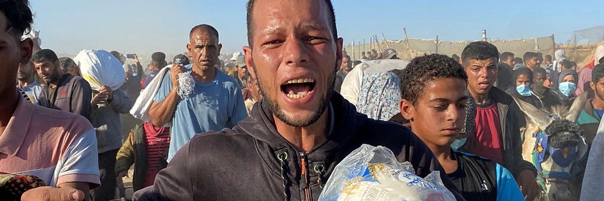 Palestinians carry bags of humanitarian relief supplies
