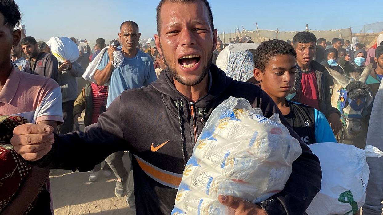 Palestinians carry bags of humanitarian relief supplies