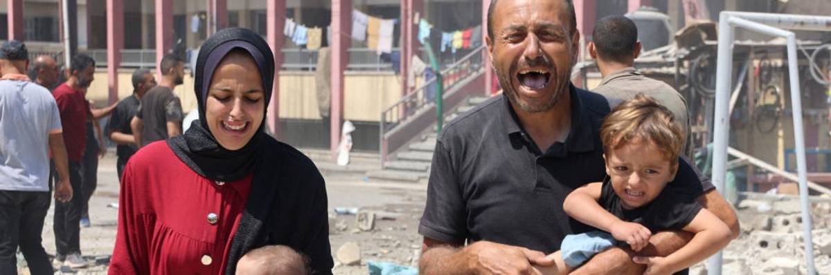 Palestinians carry children away from bombed shelter