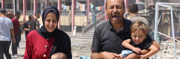 Palestinians carry children away from bombed shelter