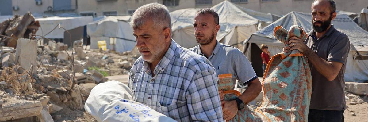 Palestinians carry wrapped bodies in Gaza