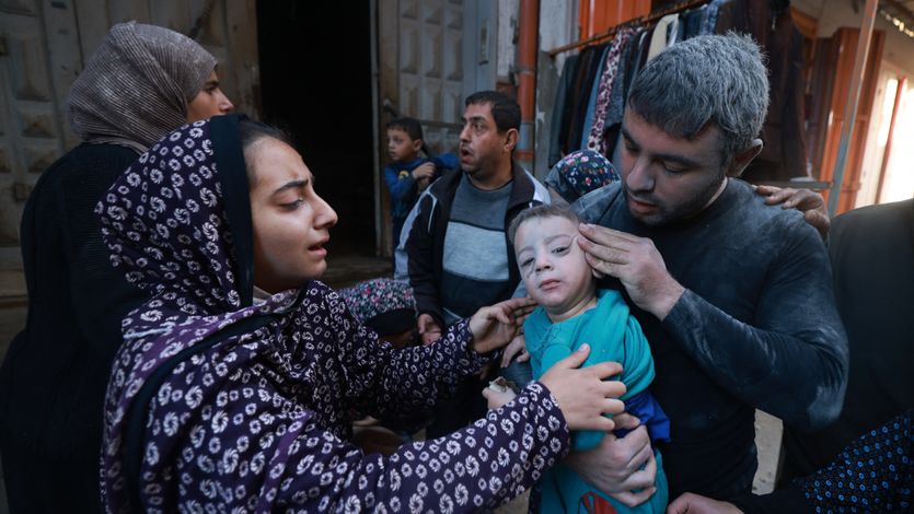 Palestinians flee with child in Rafah.