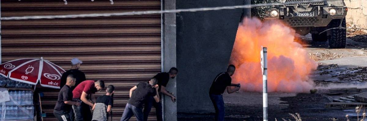 Palestinians in the Jenin refugee camp confront armored IDF vehicle