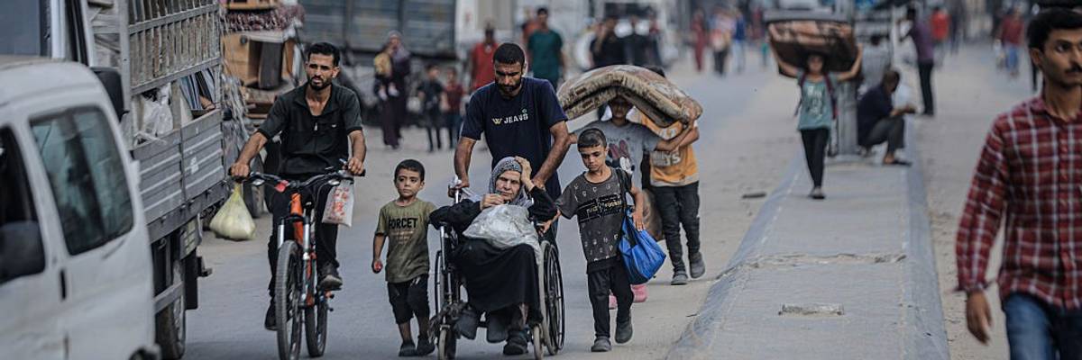 Palestinians, including children and a woman in a wheelchair, flee Gaza City