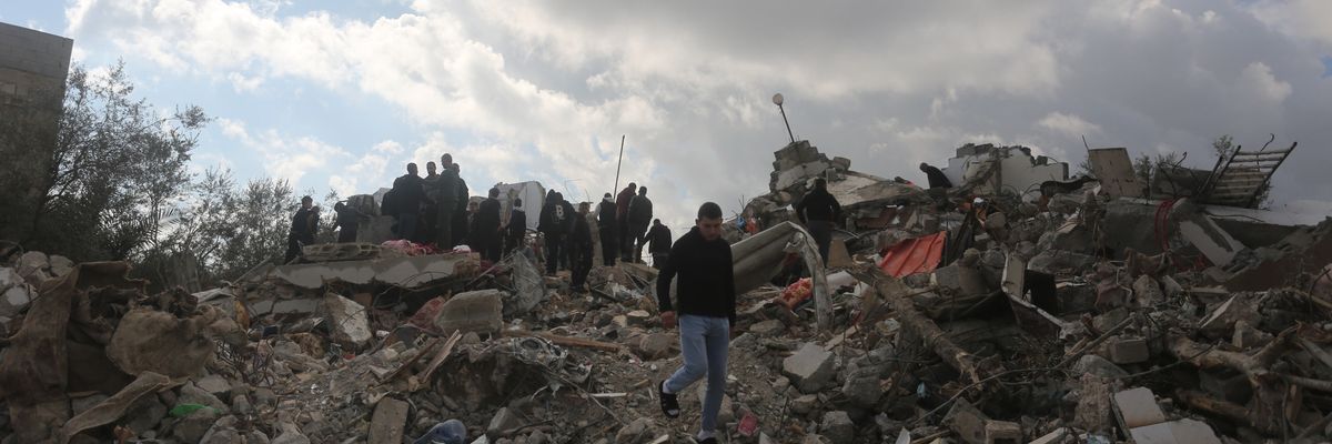 Palestinians inspect the rubble of a house