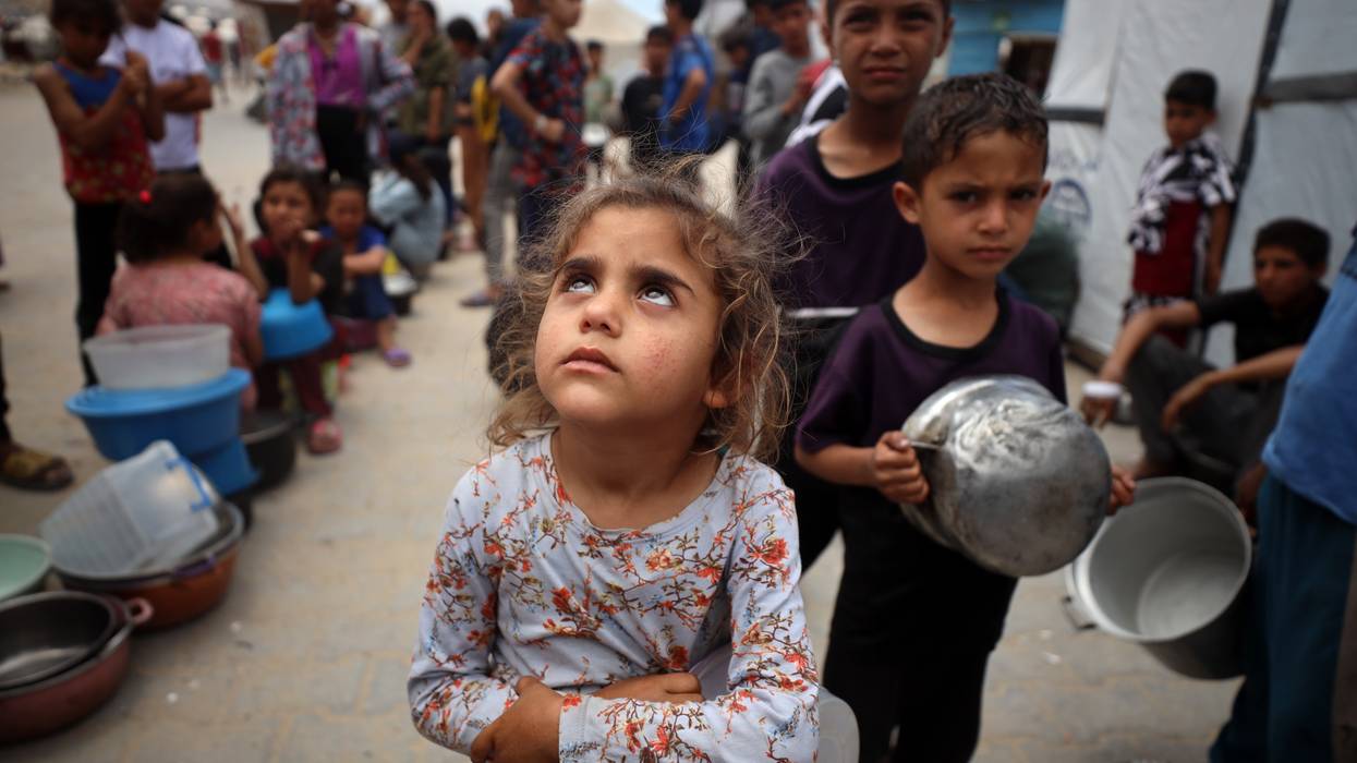 Palestinians line up to receive a hot meal at a food distribution point