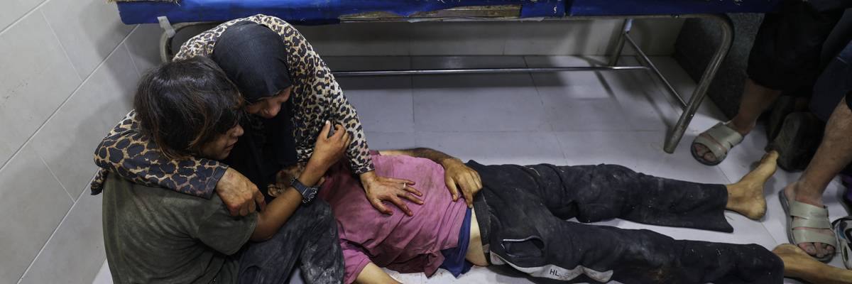 Palestinians mourn by the body of a relative killed in Israeli fire