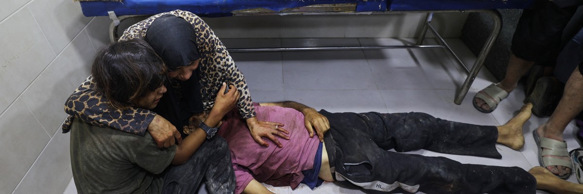 Palestinians mourn by the body of a relative killed in Israeli fire