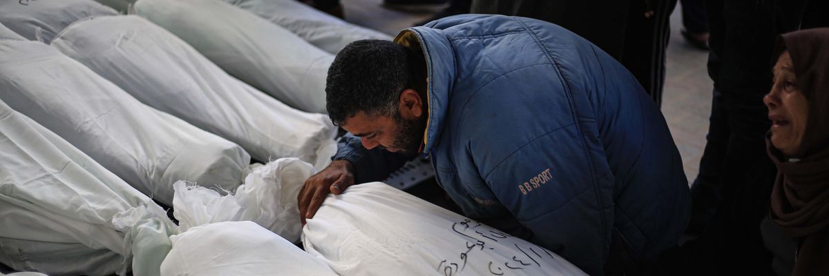 Palestinians mourn next to the bodies of their relatives