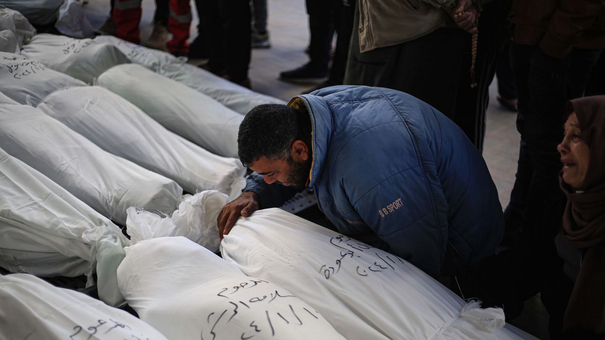 Palestinians mourn next to the bodies of their relatives