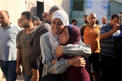Palestinians mourn over the bodies of loved ones