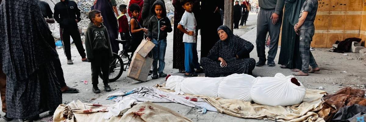 Palestinians mourn over the bodies of relatives killed by an Israeli attack