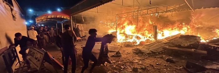 Palestinians react to an Israeli airstrike on a hospital in Gaza