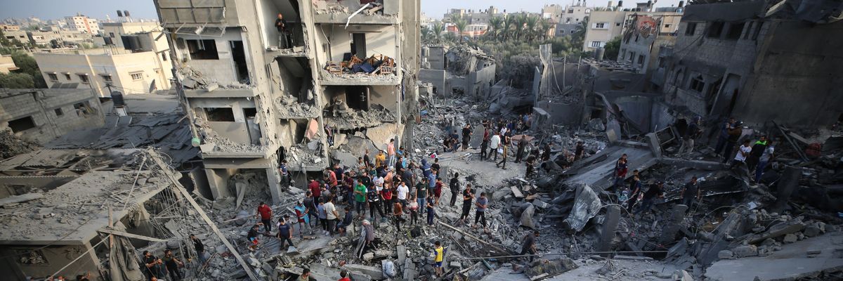 Palestinians search through the rubble of a collapsed building