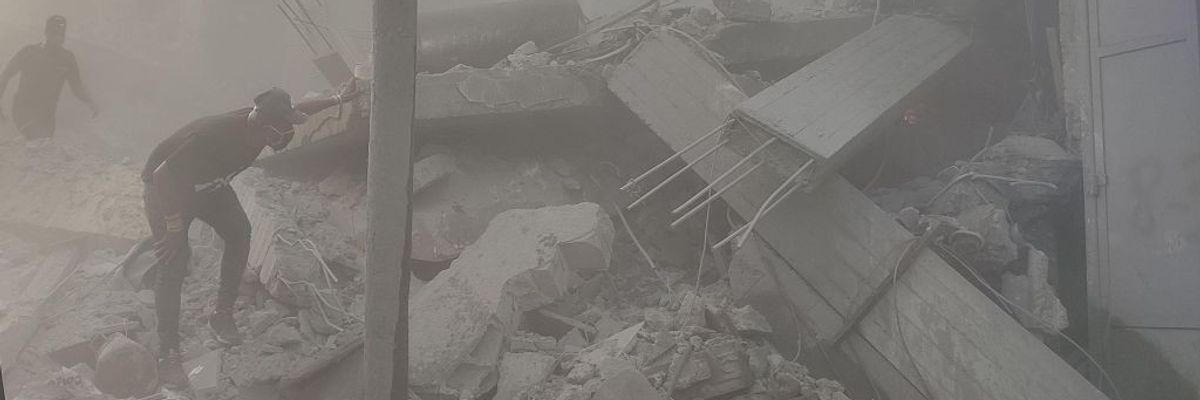 Palestinians search through the rubble of an Israeli airstrike