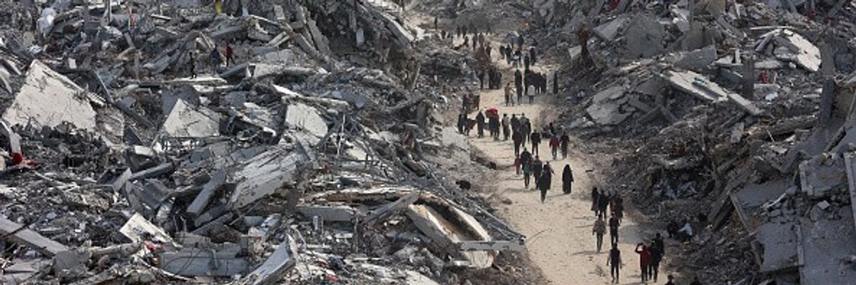 Palestinians walk among the rubble of Gaza