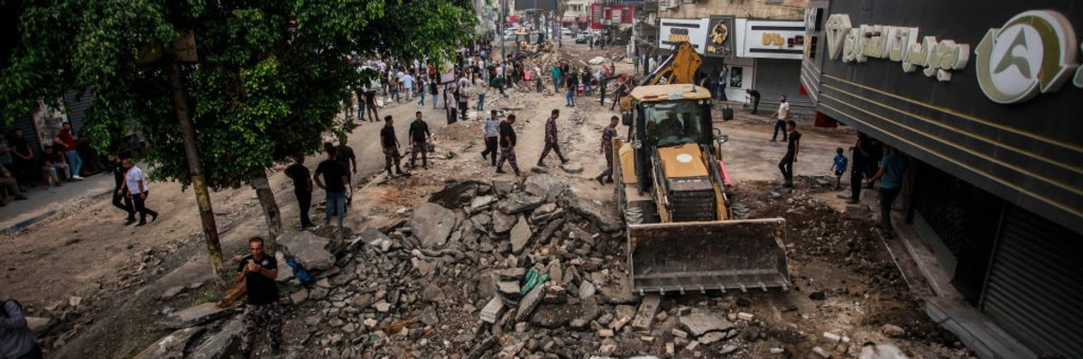 Palestinians walk around the damaged infrastructure in Jenin