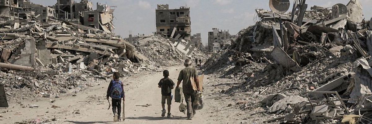 Palestinians walk through rubble in Gaza