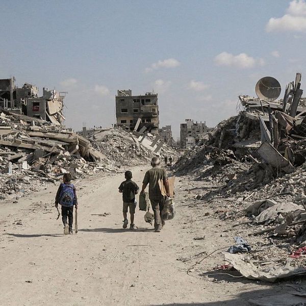 Palestinians walk through rubble in Gaza