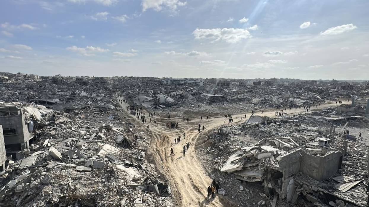 Palestinians walk through the remnants of the Jabalia refugee camp