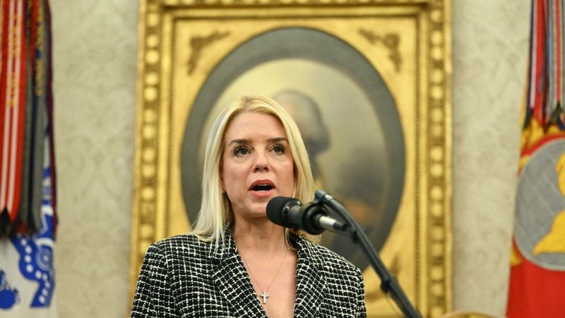 Pam Bondi speaks into a microphone.