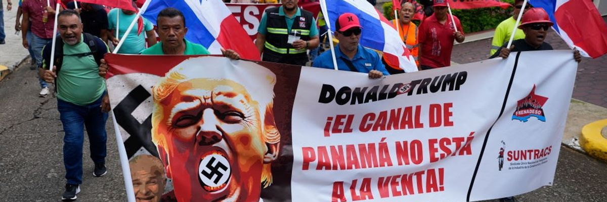 Panamanians march with a banner reading, "Donald Trump, the Panama Canal Is Not for Sale!"