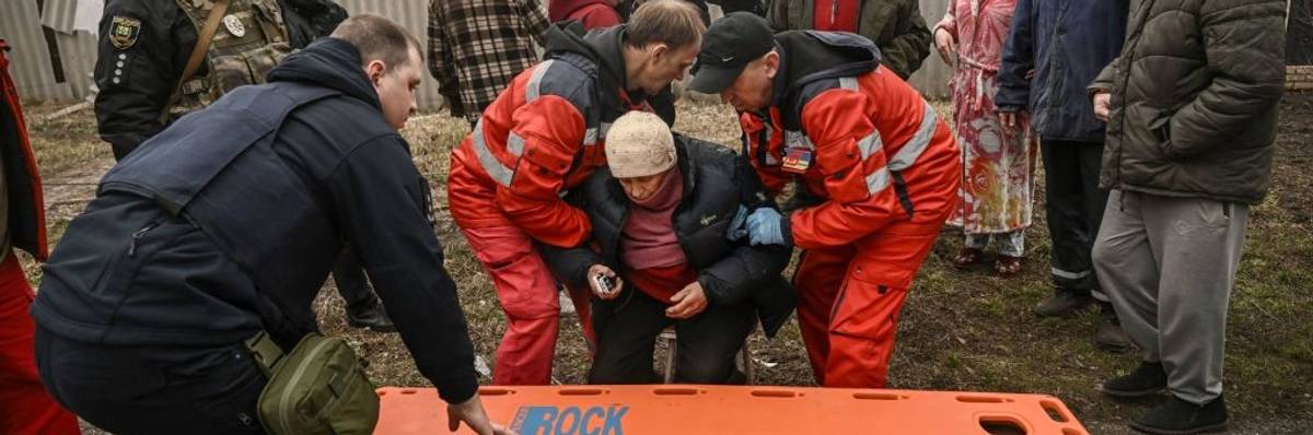 Paramedics evacuate an injured elderly woman after a cluster bomb strike in Ukraine