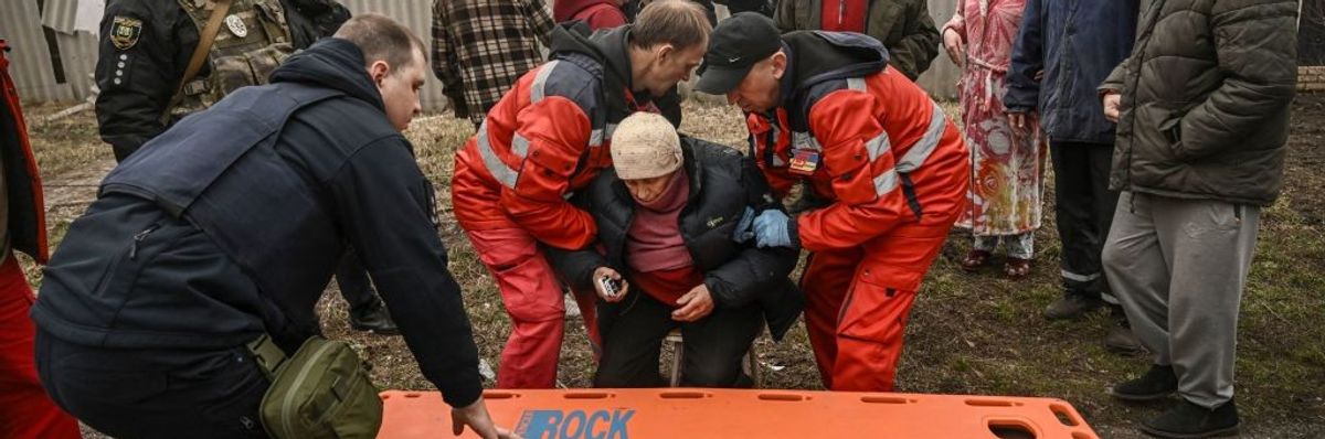 Paramedics evacuate an injured elderly woman after a cluster bomb strike in Ukraine