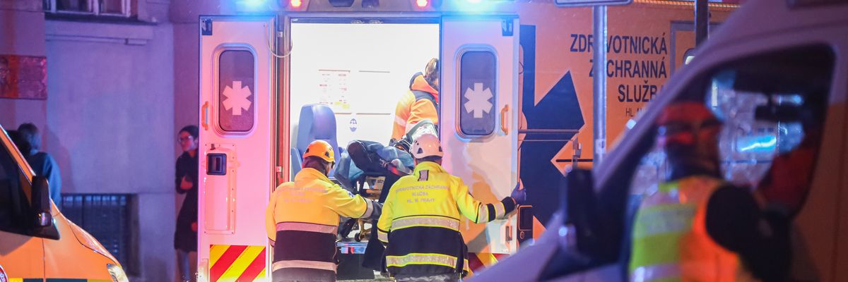 Paramedics load a stretcher into an ambulance